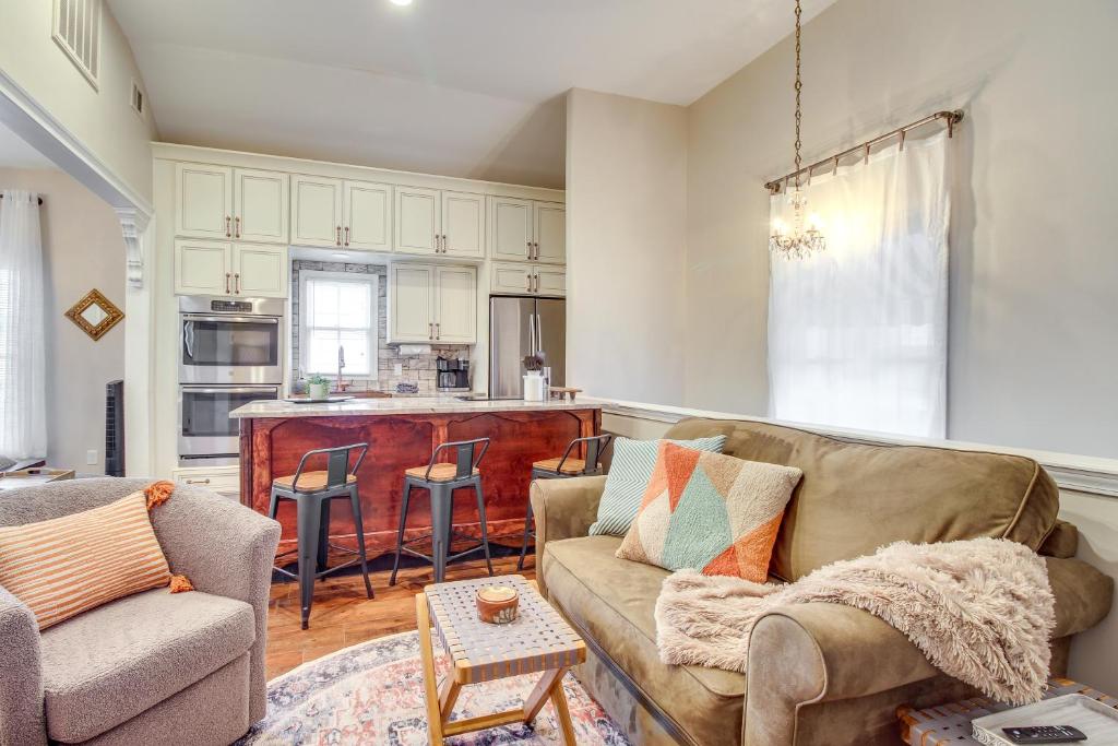 a living room with a couch and a kitchen at Cozy Savannah Vacation Rental with Fenced Courtyard! in Savannah