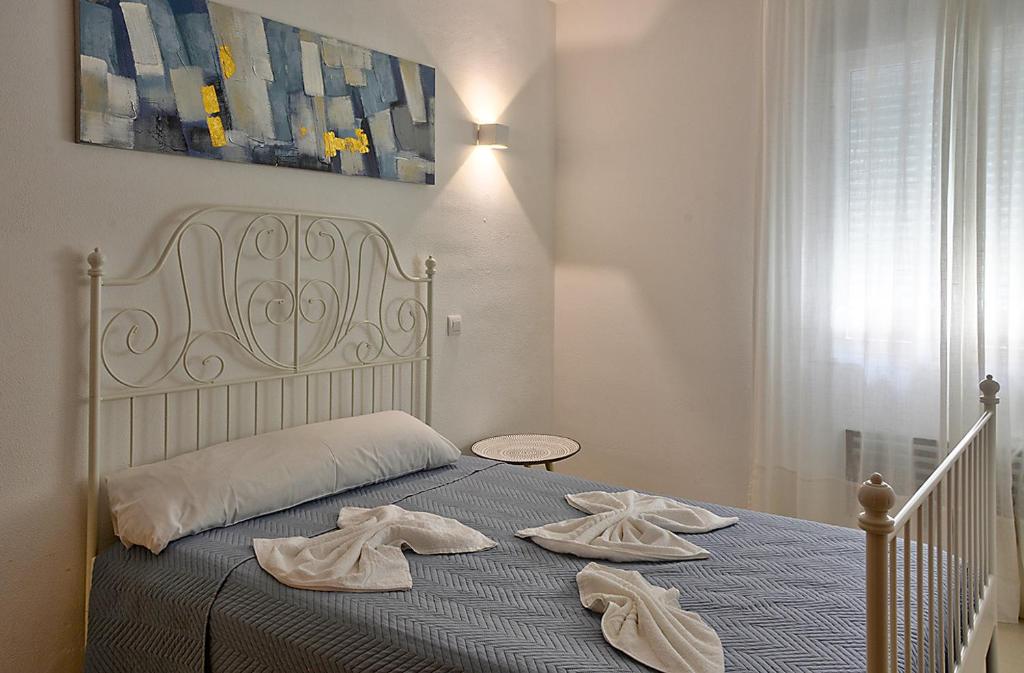 sypialnia z łóżkiem i dwoma ręcznikami na nim w obiekcie Apartamento Exclusivo en Sevilla w Sewilli