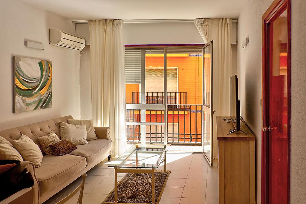 salon z kanapą i telewizorem w obiekcie Apartamento Exclusivo en Sevilla w Sewilli