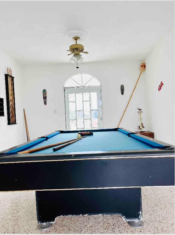 a pool table in a living room with at Hermosa casa privada con alberca. in Veracruz