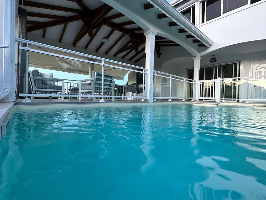 a swimming pool with blue water in a building at VILLA JASMIN : EXCEPTIONNELLE !! in Petit-Bourg