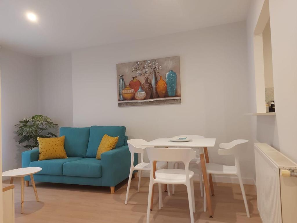 een woonkamer met een blauwe bank en een tafel bij Apartamento Silleda Confort in Silleda