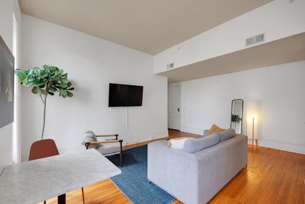 a living room with a couch and a tv on a wall at Historic Charm, Walkable Entertainment in Louisville
