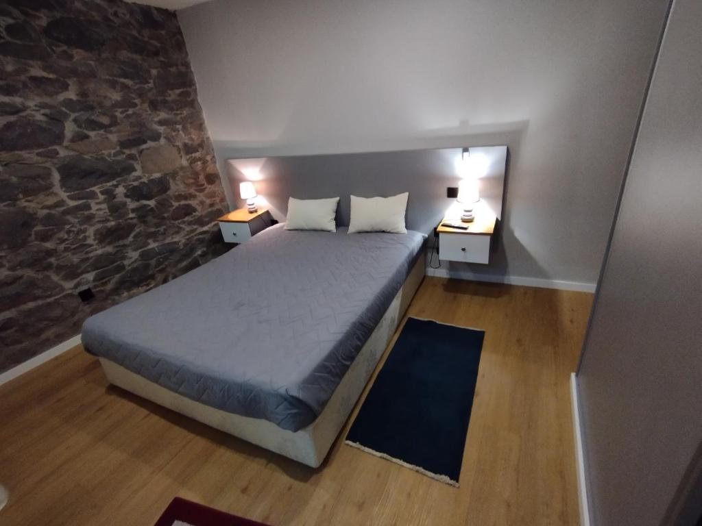 a small bedroom with a bed and two night stands at Casa do terno com piscina in Arco da Calheta