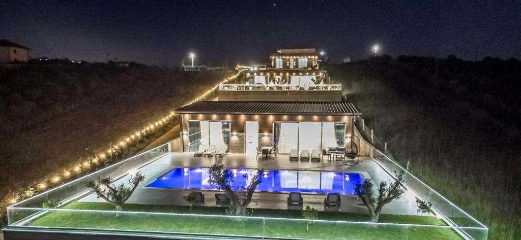 a house with a pool in front of it at night at Top Villas Durres in Durrës