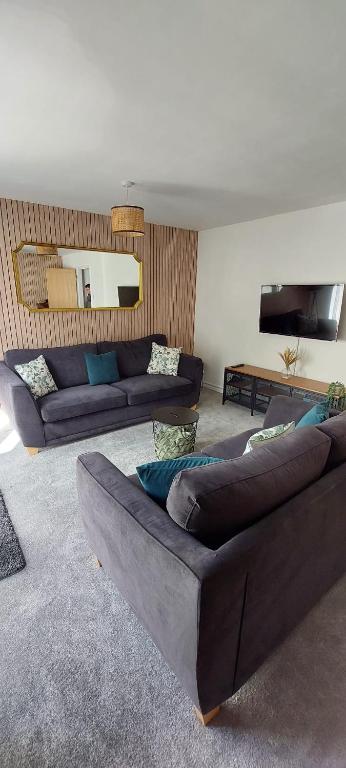 a living room with two couches and a mirror at Modern Town House in Mid Wales in Knighton