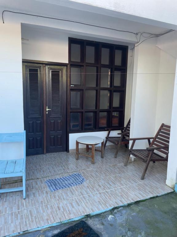 a patio with two chairs and a table and a door at Condomínio Canto das Orquídeas VI in Porto Seguro