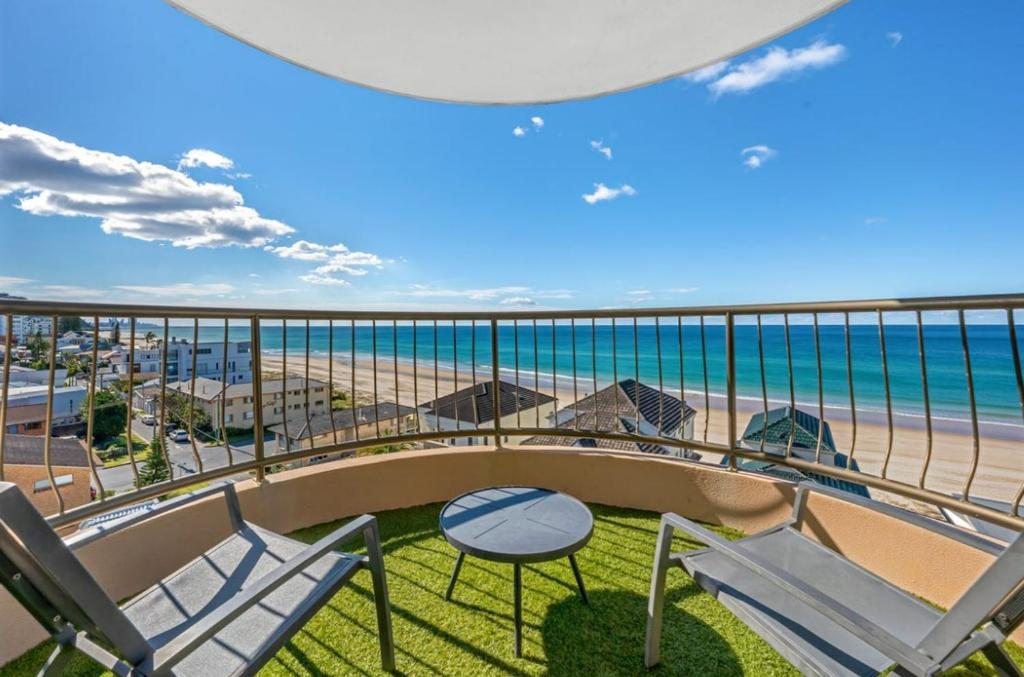 einen Balkon mit Stühlen, einem Tisch und Strand in der Unterkunft Seascape - Hosted by Burleigh Letting in Gold Coast