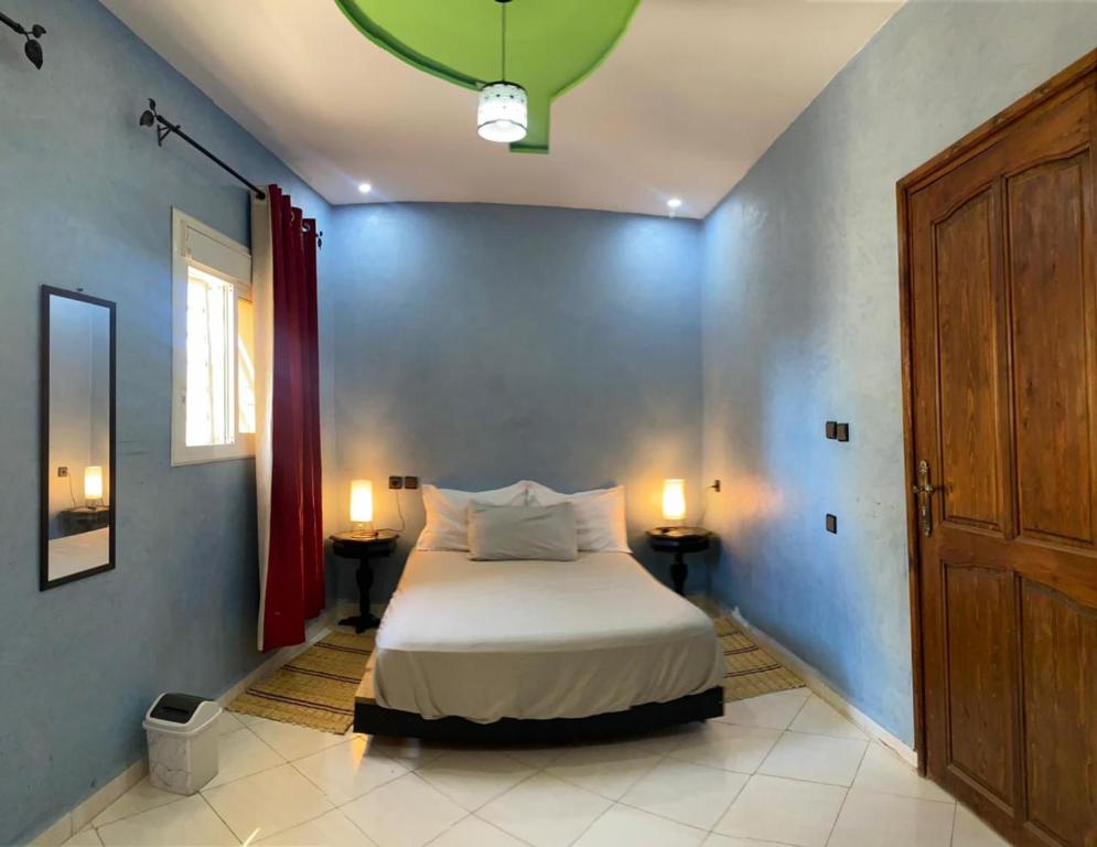 a bedroom with a bed and two lamps and a door at Appartement marocain proche de la mer à Sidi Bouzid in Safi