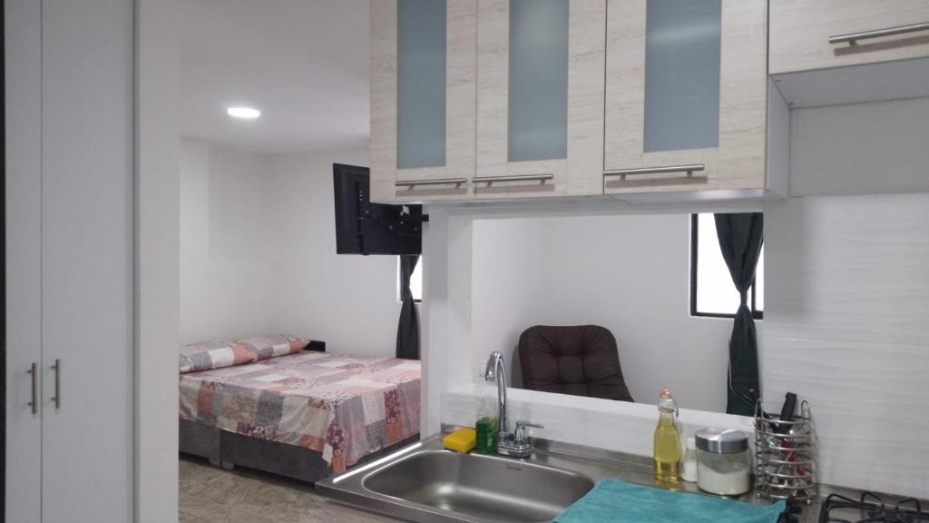 uma pequena cozinha com um lavatório e uma cama em Apto 202 em Cúcuta