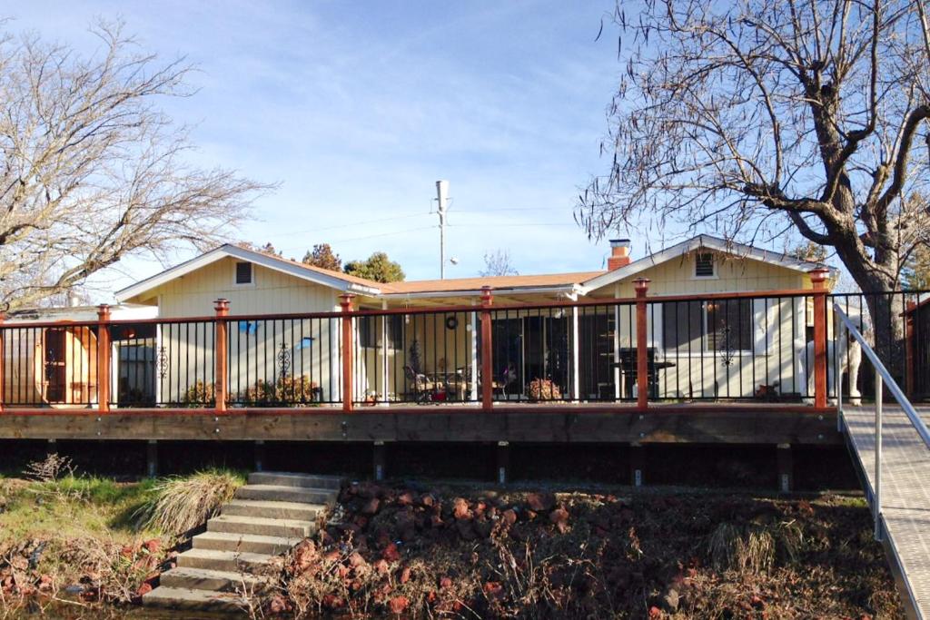 a house with a wooden deck and stairs at Clearlake Charmer in Clearlake Oaks