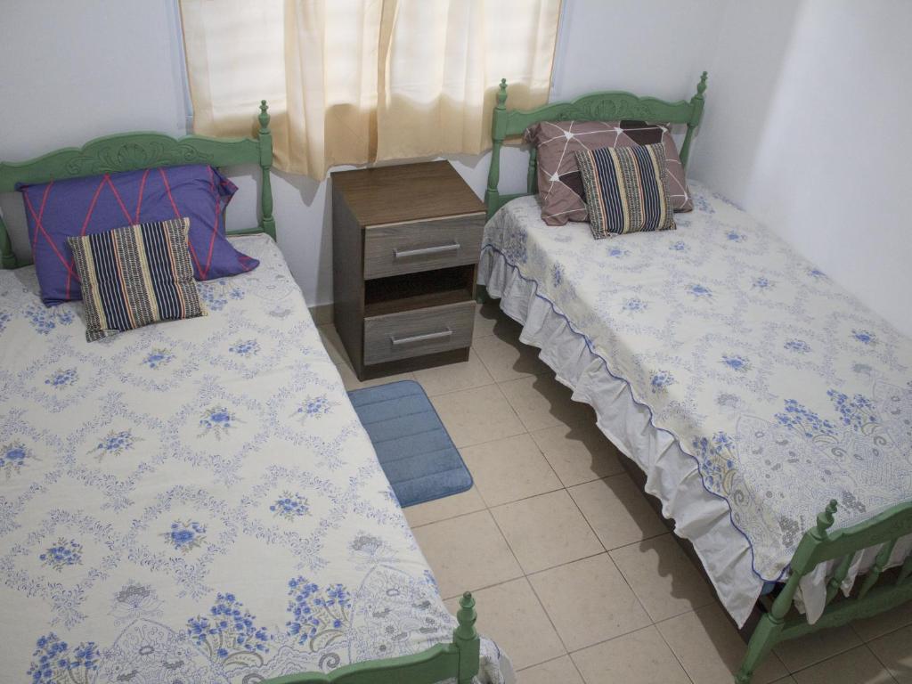 - une chambre avec 2 lits et une table de nuit dans l'établissement Fica à vontade, à San Salvador de Jujuy