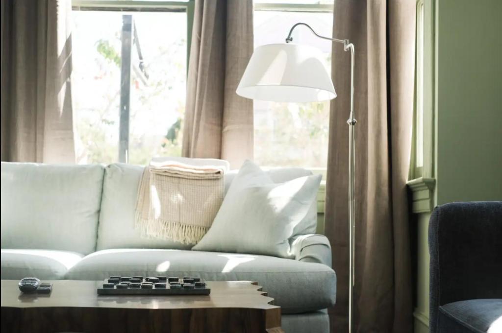 a living room with a white couch and a lamp at The Juliette - Luxury Historic Residence in Charleston