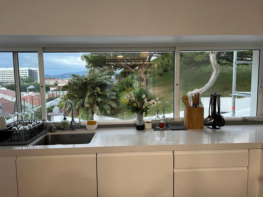 a kitchen with a sink and a large window at Casa Sonho Azores - AL 1449 in Ponta Delgada
