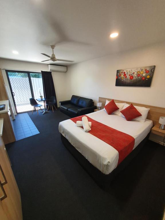 a bedroom with a large bed and a living room at Abode37 Motel Emerald in Emerald