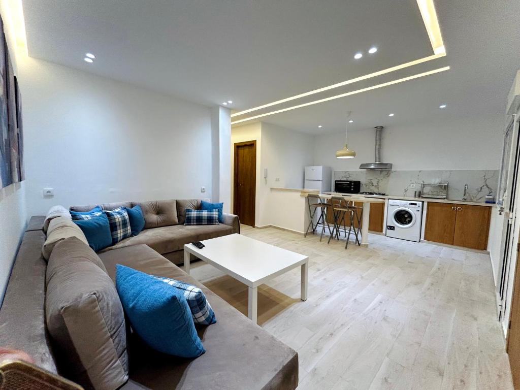 a living room with a couch and a table at Appartement de standing in Martil