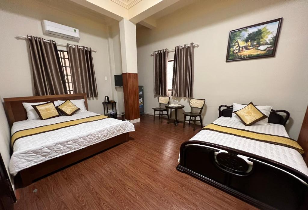 um quarto com 2 camas, uma mesa e cadeiras em MERU em Ho Chi Minh