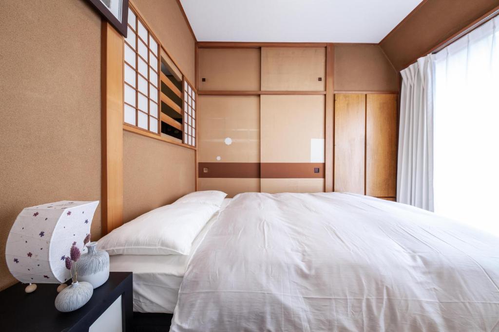 sypialnia z dużym białym łóżkiem i oknem w obiekcie Second kuwamura building w Tokio