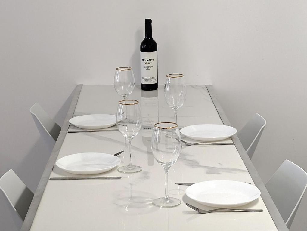 a table with glasses and plates and a bottle of wine at L'Eclat - Hypercentre / Quai de Grenoble in Grenoble