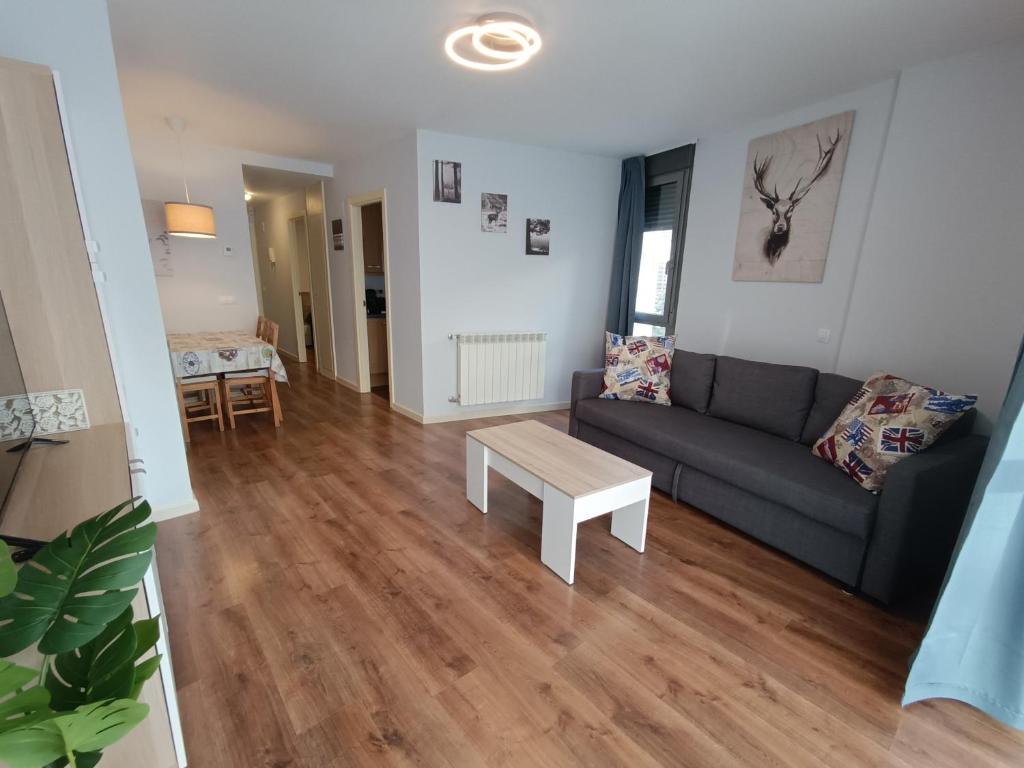a living room with a couch and a table at Margas Golf Apartment 2 in Sabiñánigo