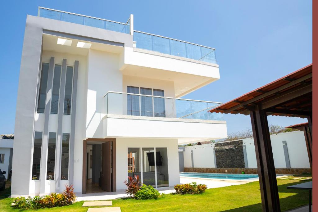 Juan de Acosta的住宿－Villa Sol Deluxe，带阳台和游泳池的白色房屋