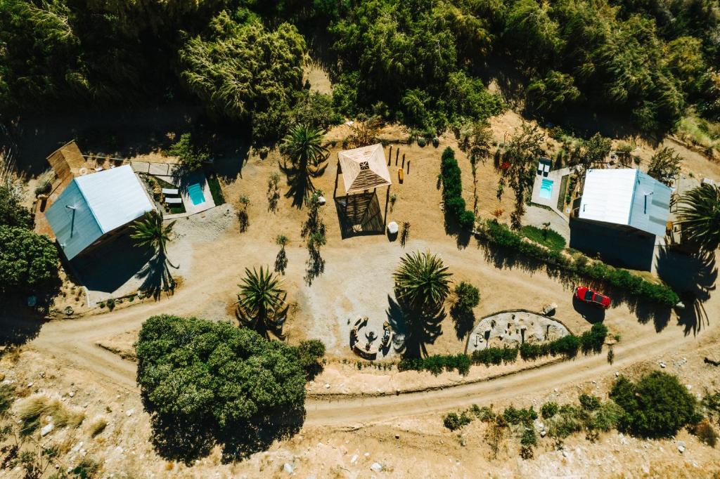 an overhead view of a house with trees and a road at Piuquenes Lodge - Cabañas Valle de Elqui in Horcon