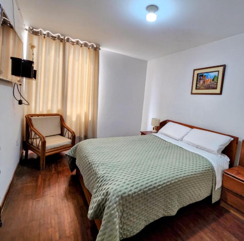 Habitación de hotel con cama y silla en Casa Cultura, en Lima