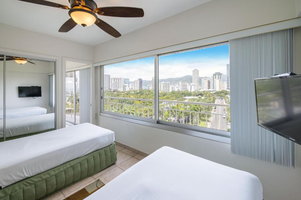 1 dormitorio con 2 camas y ventana grande en Waikiki Shore by OUTRIGGER, en Honolulu