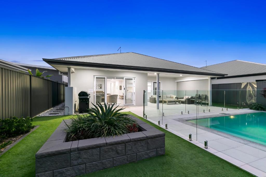 a house with a swimming pool in the yard at OSPREY ISLAND RETREAT in Banksia Beach