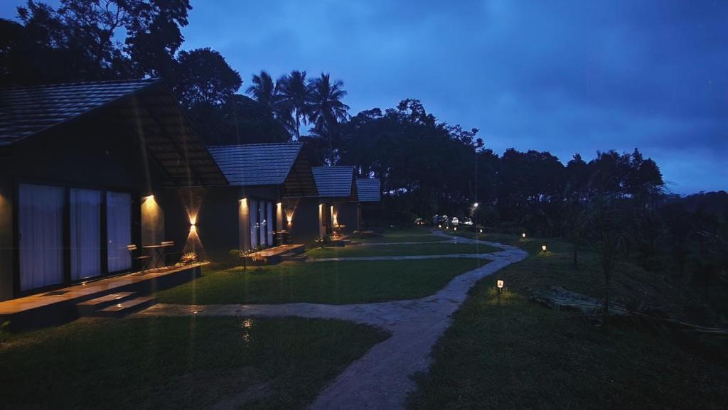 un chemin menant à une maison la nuit dans l'établissement Bendheka - Cliff Front Cottages Coorg, à Gonikoppal