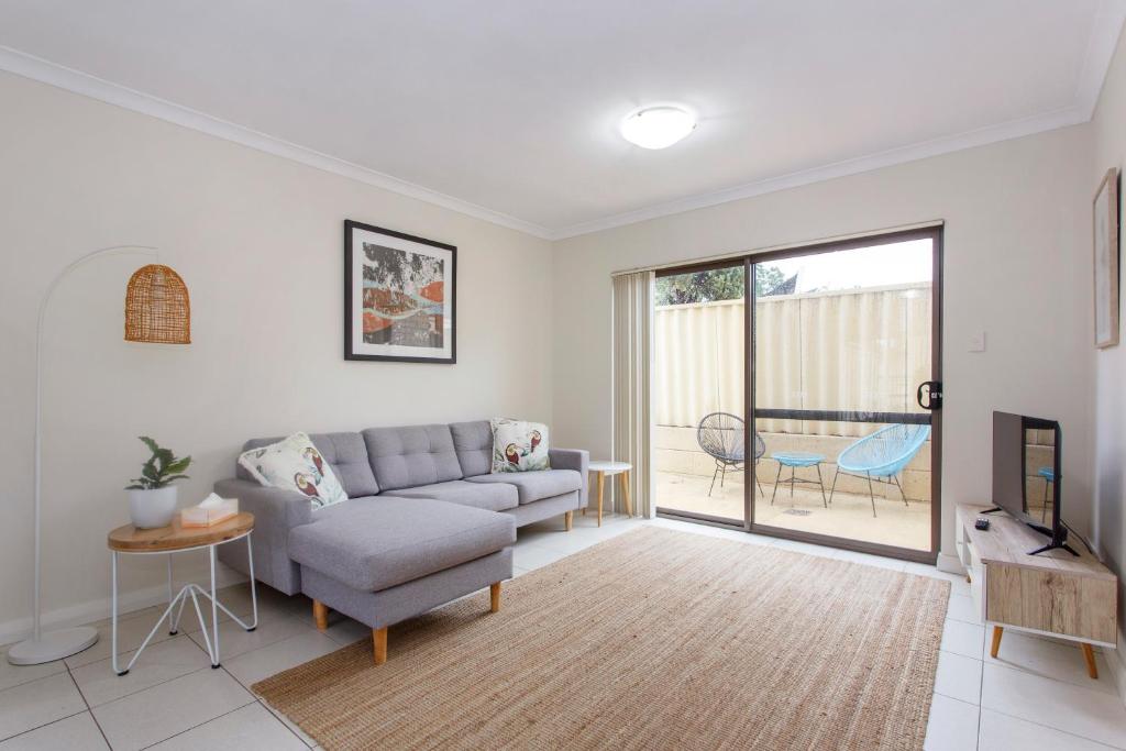 a living room with a couch and a tv at Casa Toucan - 2 bedroom apartment close to the airport in Perth