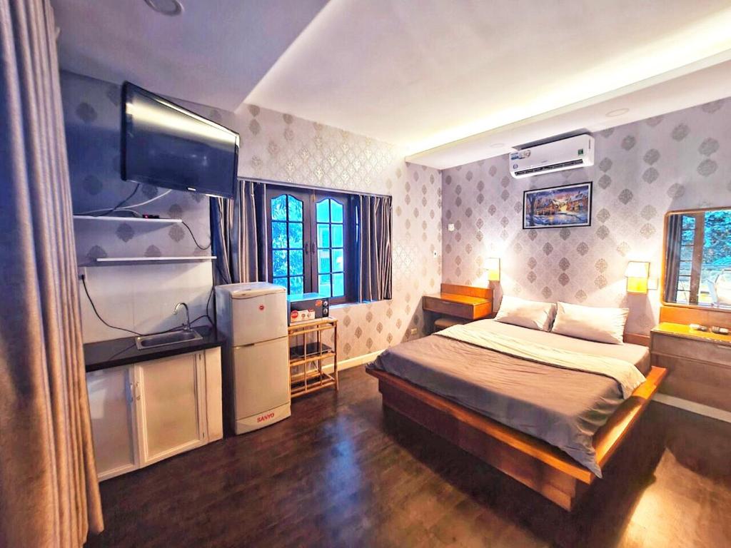 - une chambre avec un lit et une télévision dans l'établissement Cactusland Villa Near Bui Vien Street, à Hô-Chi-Minh-Ville