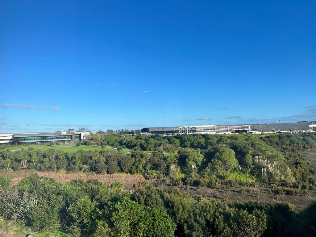 an aerial view of a building on a hill with trees at Manha Hotel Auckland Airport in Auckland