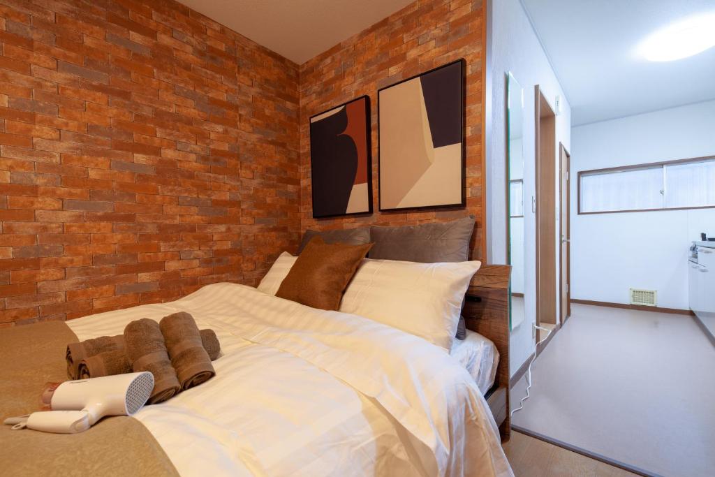- une chambre avec un grand lit et un mur en briques dans l'établissement Ko-Fu-Sou, à Tokyo