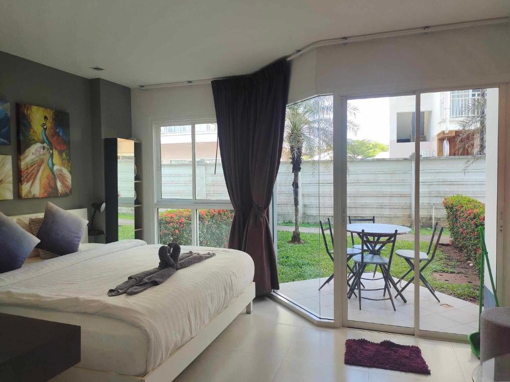1 dormitorio con cama, mesa y patio en GrandBlue Condo 102 by malai, en Mae Pim