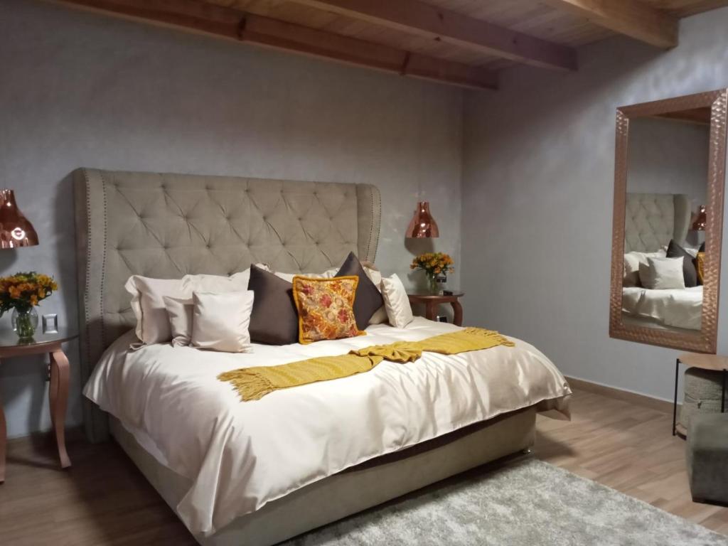 a bedroom with a large bed and a mirror at Casa Neek in San Cristóbal de Las Casas