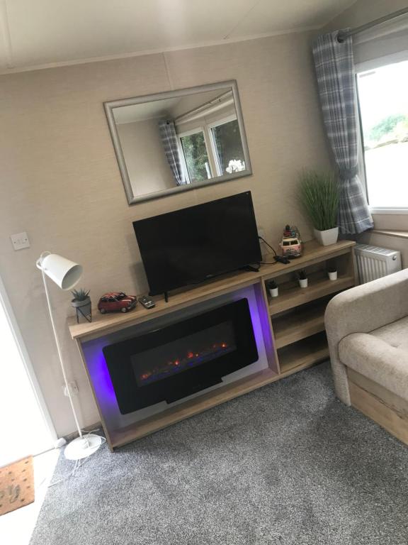 a living room with a flat screen tv on a entertainment center at Static stays in Longridge