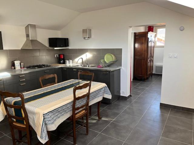 une cuisine avec une table et des chaises et une cuisine avec un évier dans l'établissement Repos et loisirs en moyenne montagne, à Chorges