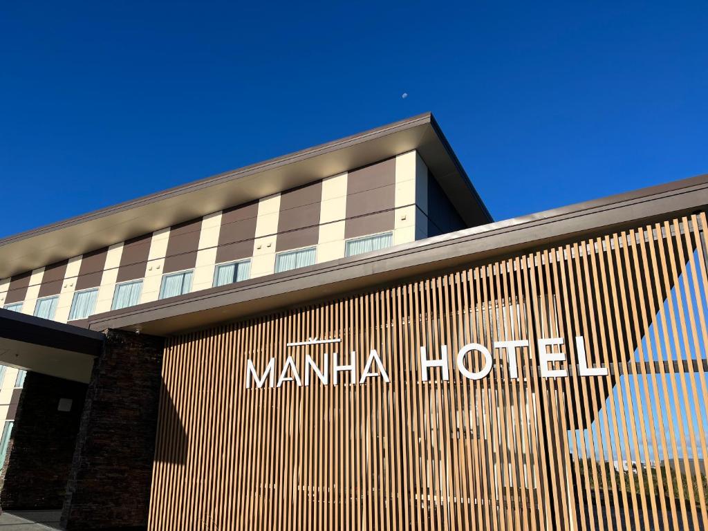 a building with a sign on the side of it at Manha Hotel Auckland Airport in Auckland