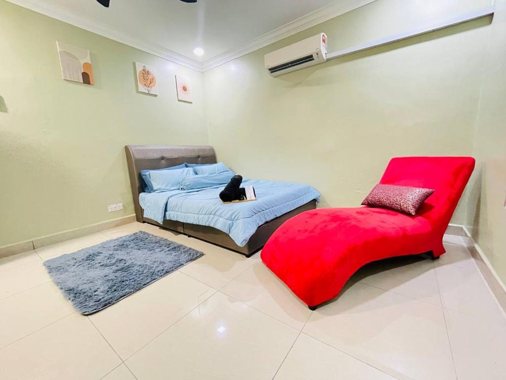 un dormitorio con un gato sentado en una cama y una silla roja en Goodvibes#HomeNearSenaiAirport#Aeon#IOI en Kulai