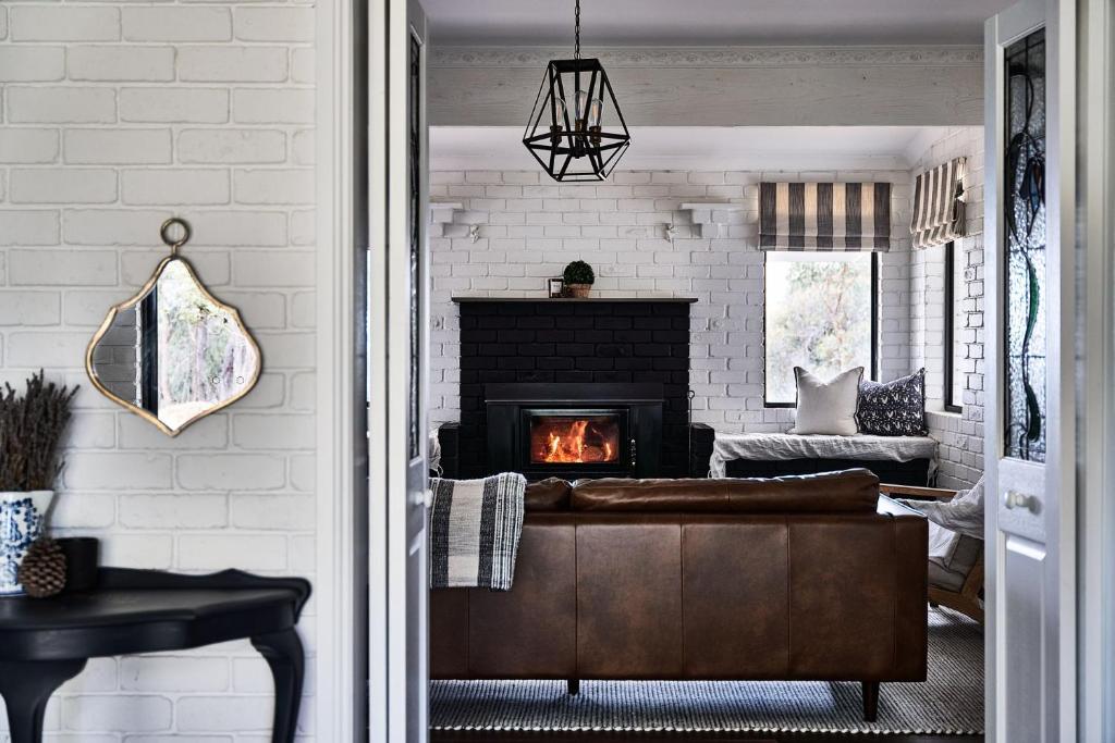 a living room with a couch and a fireplace at Vermont House - Daylesford Macedon Region in Elphinstone
