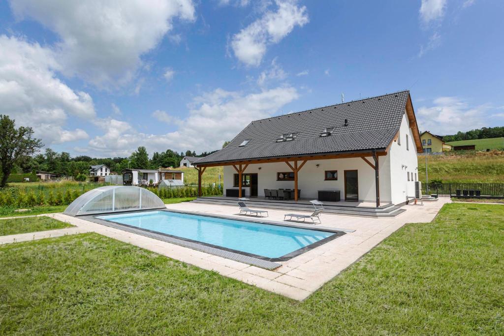 une maison avec une piscine dans la cour dans l'établissement Holiday House Adam, à Prosečné