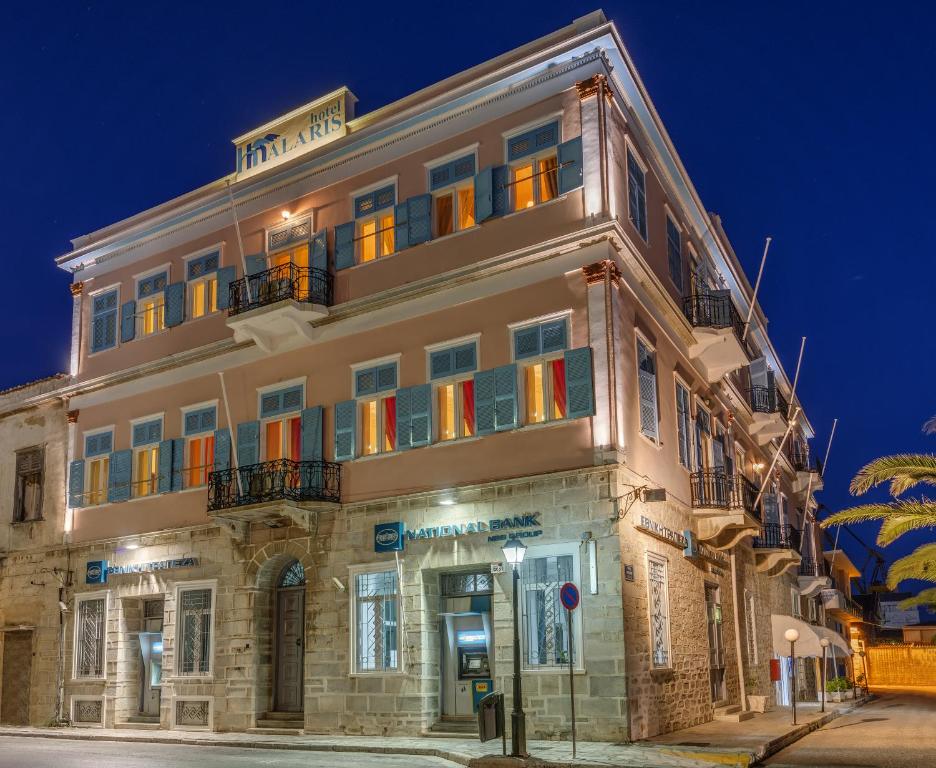 un gran edificio con ventanas coloridas en una calle en Hotel Halaris, en Ermoupoli