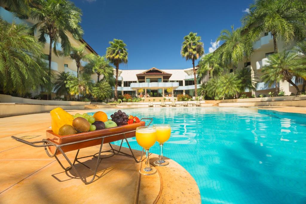 uma bandeja de frutas e bebidas junto a uma piscina em Wetiga Hotel em Bonito
