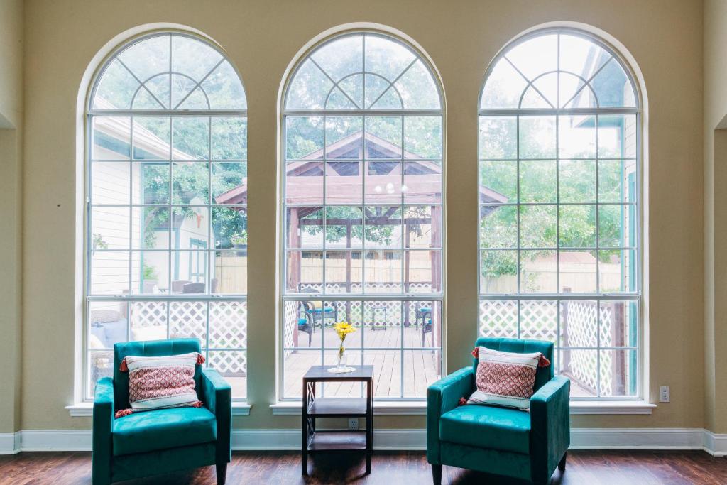 a room with three windows and two chairs and a table at Sunflower Ranch in Pflugerville