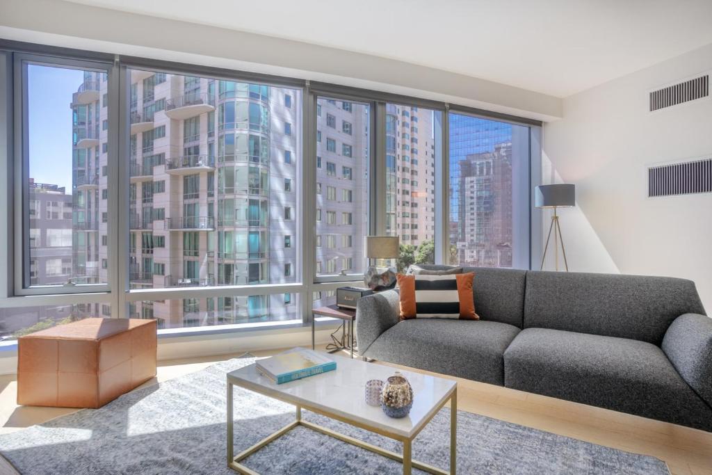 a living room with a couch and large windows at Rincon Hill 1BR w AC Gym nr Bay Bridge SFO-156 in San Francisco