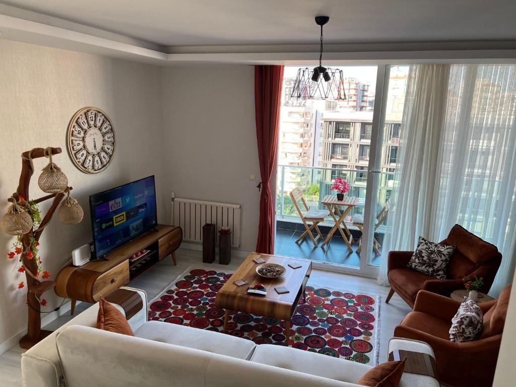 een woonkamer met een bank en een tv bij Mersin'in en lüks ve en güzel 2+1 evi in Mersin