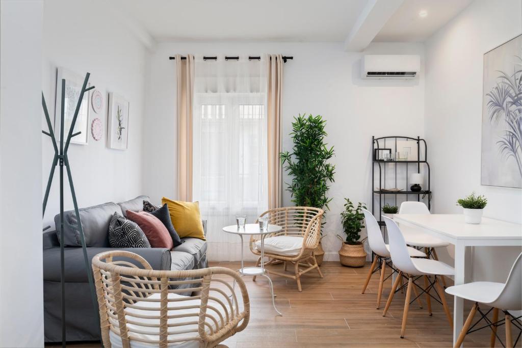 a living room with a couch and a table and chairs at Magno Apartments Miño in Seville