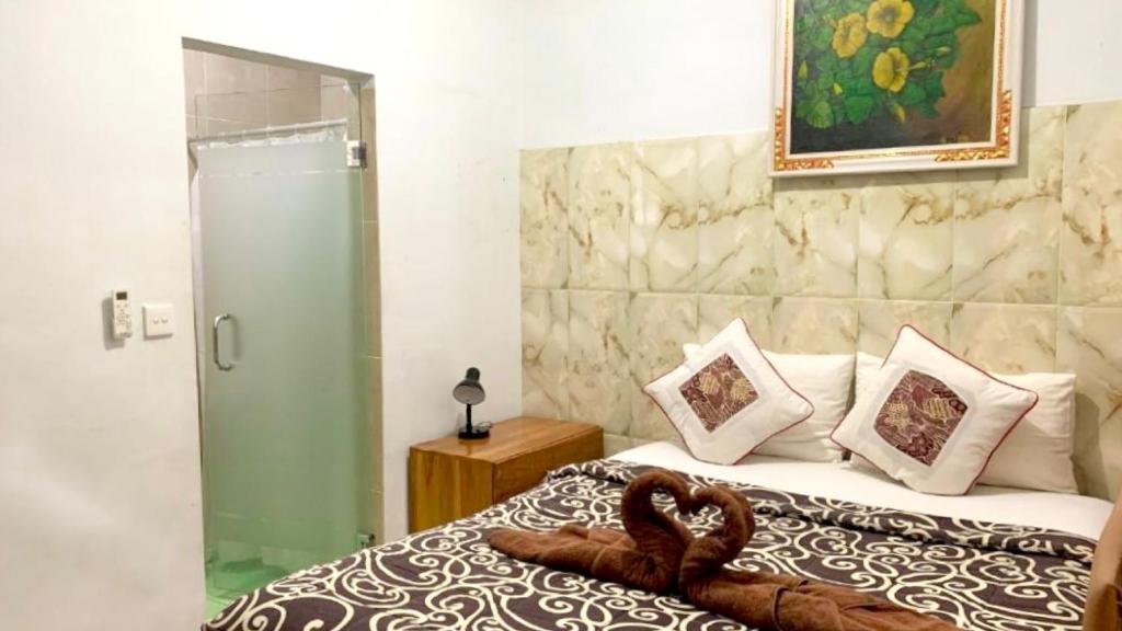 Un dormitorio con una cama con una serpiente de toalla. en Gustav Bali Homestay and Massage, en Sanur