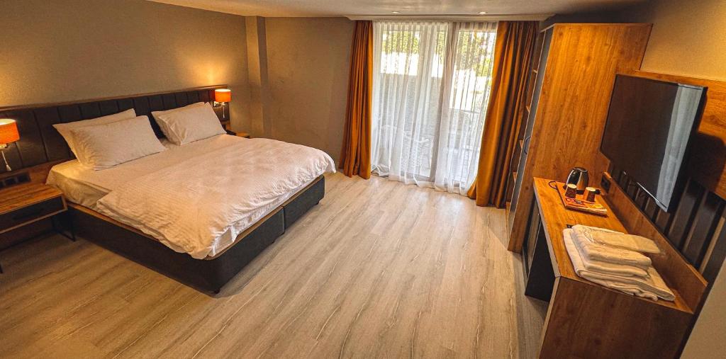- une chambre avec un lit et une télévision à écran plat dans l'établissement Çamlıca Hotel, à Pelitli